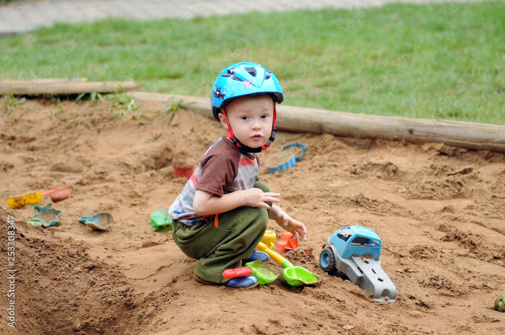 Little boy on sandbox with toys Little boy on sandbox with toys