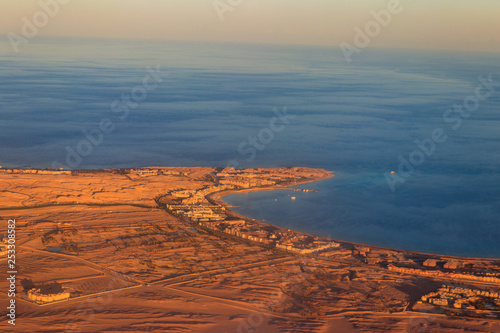 Aerial view on Red sea, Arabian desert and touristic resort near Hurghada, Egypt. View from airplane