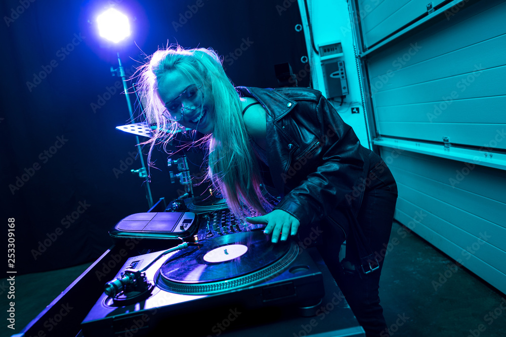 Fototapeta happy dj girl touching vinyl record in nightclub