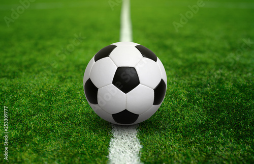 Soccer ball on green football field