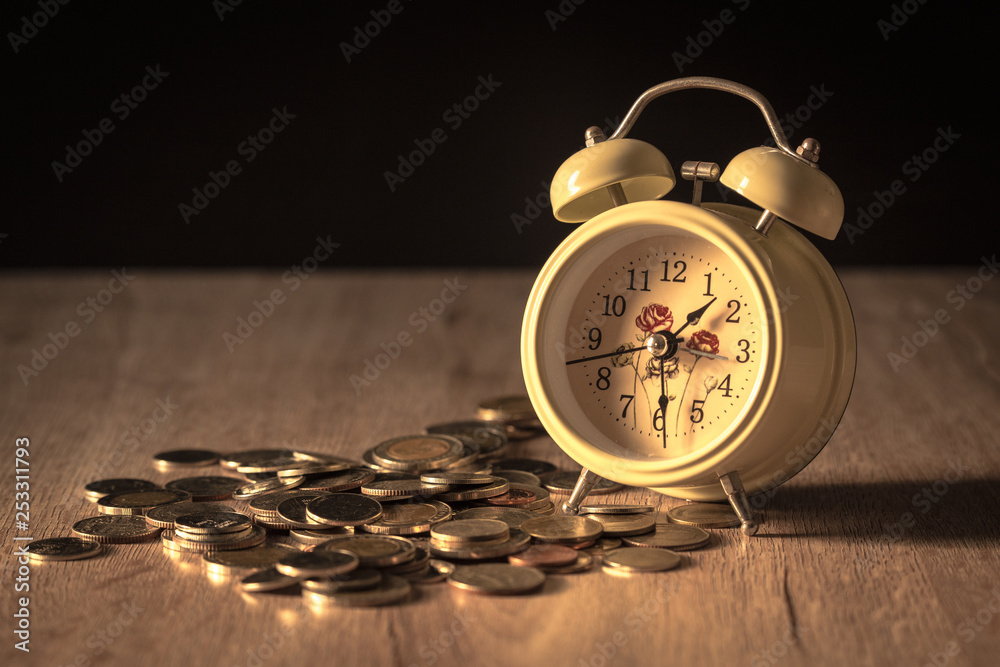 Clock and coins on wooden table, Money and time theme. Clock and coins on wooden table, Money and time theme.