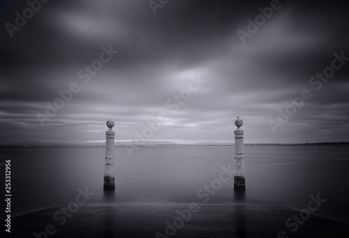 Minimalistic black and white landscape with Columns Pier (Cais das Colunas). Quay of river Tejo, long exposure. Lisbon, Portugal