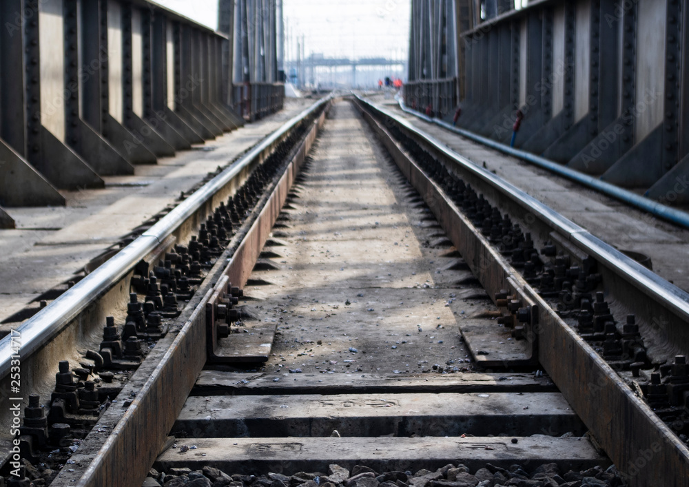 railway rails on a metal bridge go into perspective