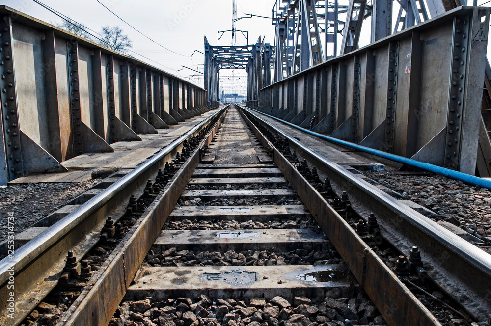 railway rails on a metal bridge go into perspective