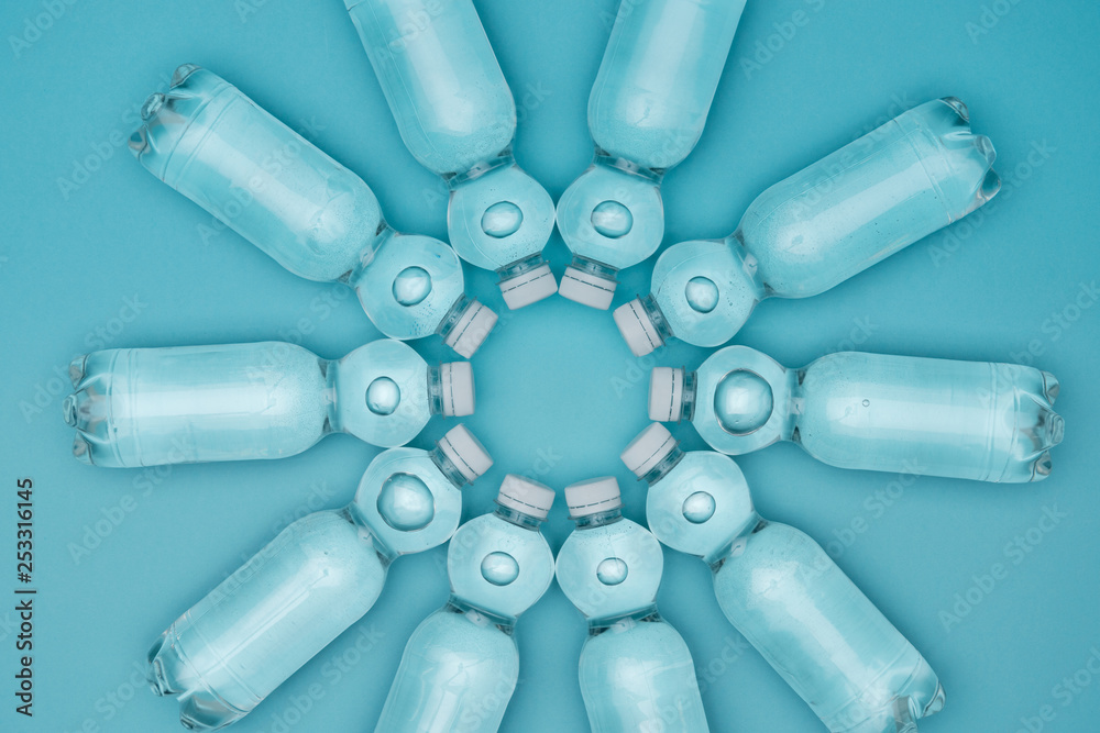 top view of plastic water bottles with bubbles isolated on turquoise top view of plastic water bottles with bubbles isolated on turquoise