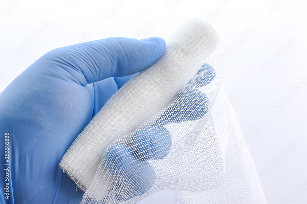 A sterile bandage in a hand. Hand holding a sterile bandage. Roll of