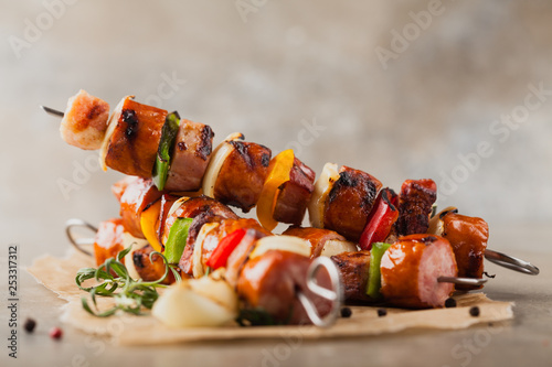 Grilled skewers with sausage, bacon and vegetables. photo