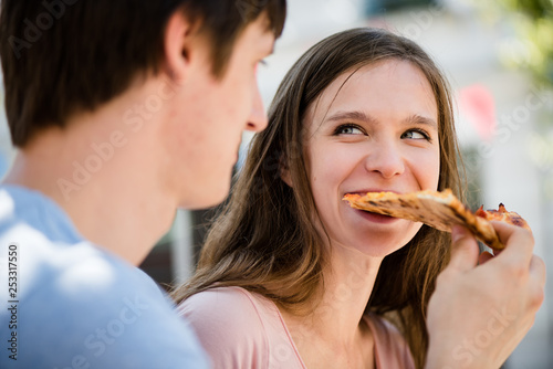 Cheerful couple sharing a slice of pizza