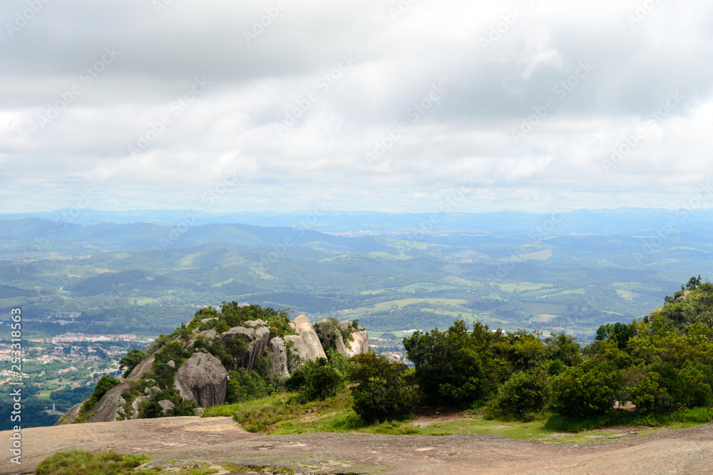 Rocky and green landscape of the mountains of Pedra Grande park in Atibaia, Sao Paulo, Brazil. In the back ground aerial view of the city of Atibaia