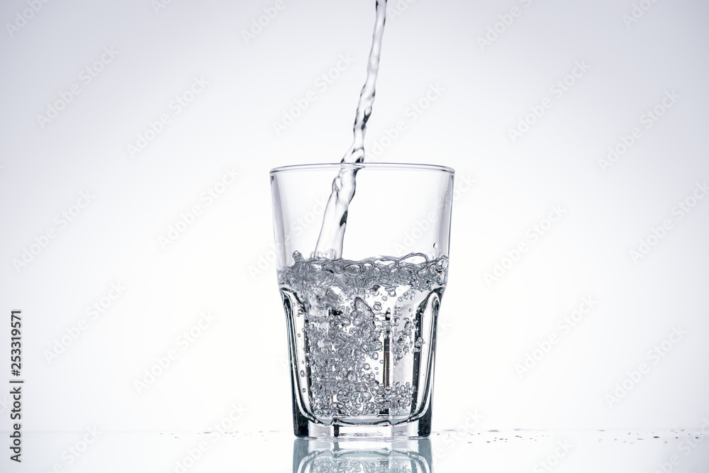 background of water pouring in glass on white with backlit background of water pouring in glass on white with backlit