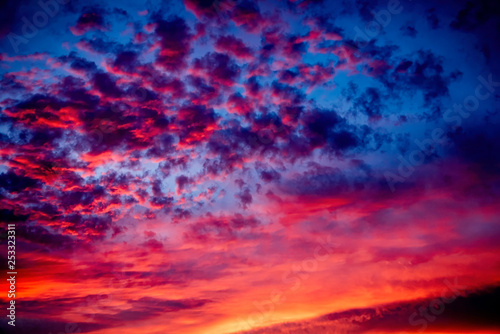 A majestic and awe-inspiration combination of deep blue sky and fiery orange and yellow clouds at sunset.