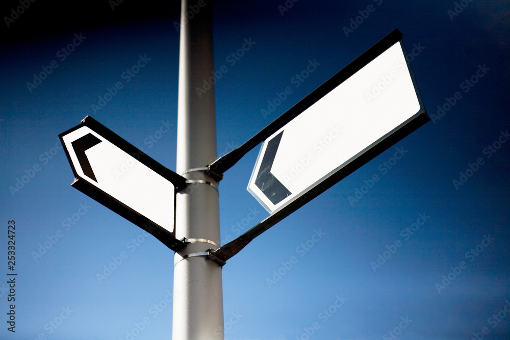 Two blank arrow signs on a lamppost.  Decisions, choices, frustration, crossroads concepts
