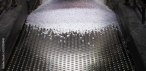 Fotografie White pellets of thermal polymer being sorted on the production line as part of the industrial manufacturing process