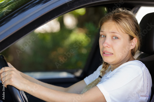 woman driver in car with expression of regret © auremar