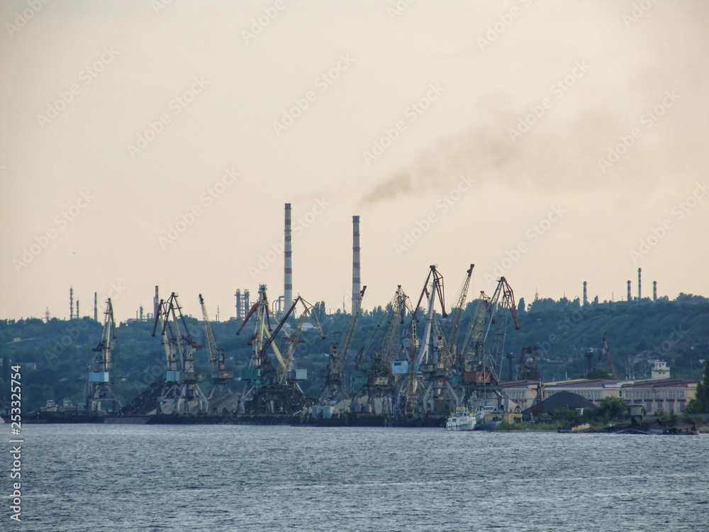 View of the port, cranes and oil refinery pipes which pollute the atmosphere