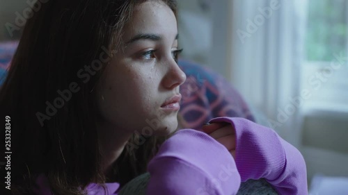 sad teenage girl crying at home feeling alone depressed teen thinking of emotional break up sitting in bedroom