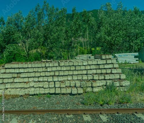 Italy, pile of wooden logs by the track side on the Italian outskirts