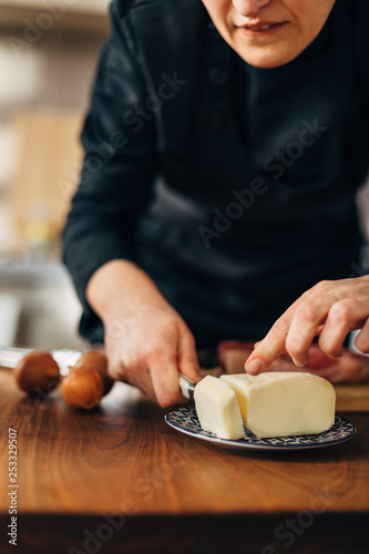 Chef cutting butter on a wooden board