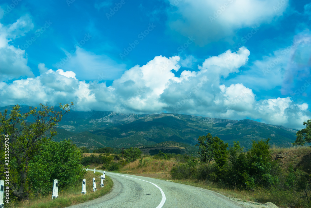 A nice road with blue sky and white clouds and mountain background