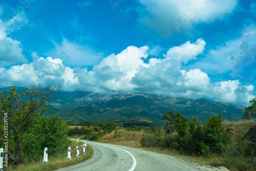 A nice road with blue sky and white clouds and mountain background