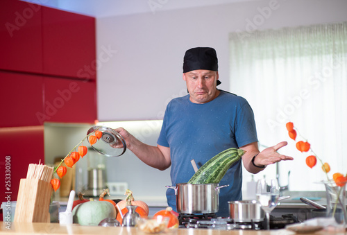  Man cooking  pumpkins with kitchen utensils at kitchen table, cooking in kitchen concept photo