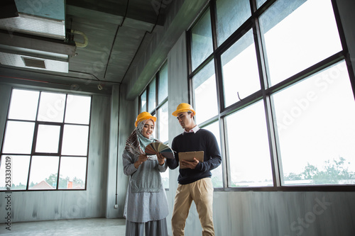 two worker choosing a good paint color to applicated in the wall of new building photo