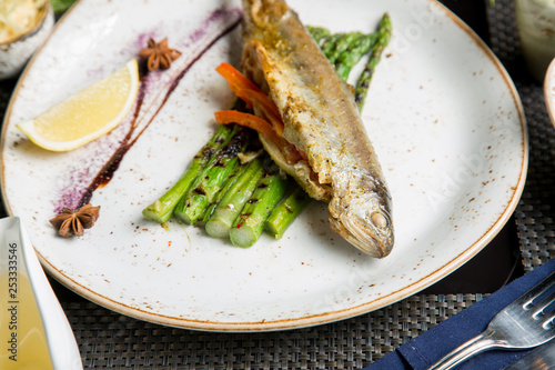 Fried fish with appetizers and white wine. Caucasian cuisine.