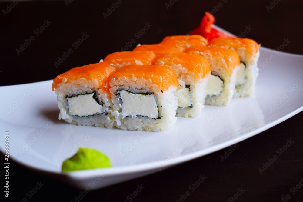 Delicious fresh rolls, Philadelphia, on white plate and black background. Delicious fresh rolls, Philadelphia, on white plate and black background.