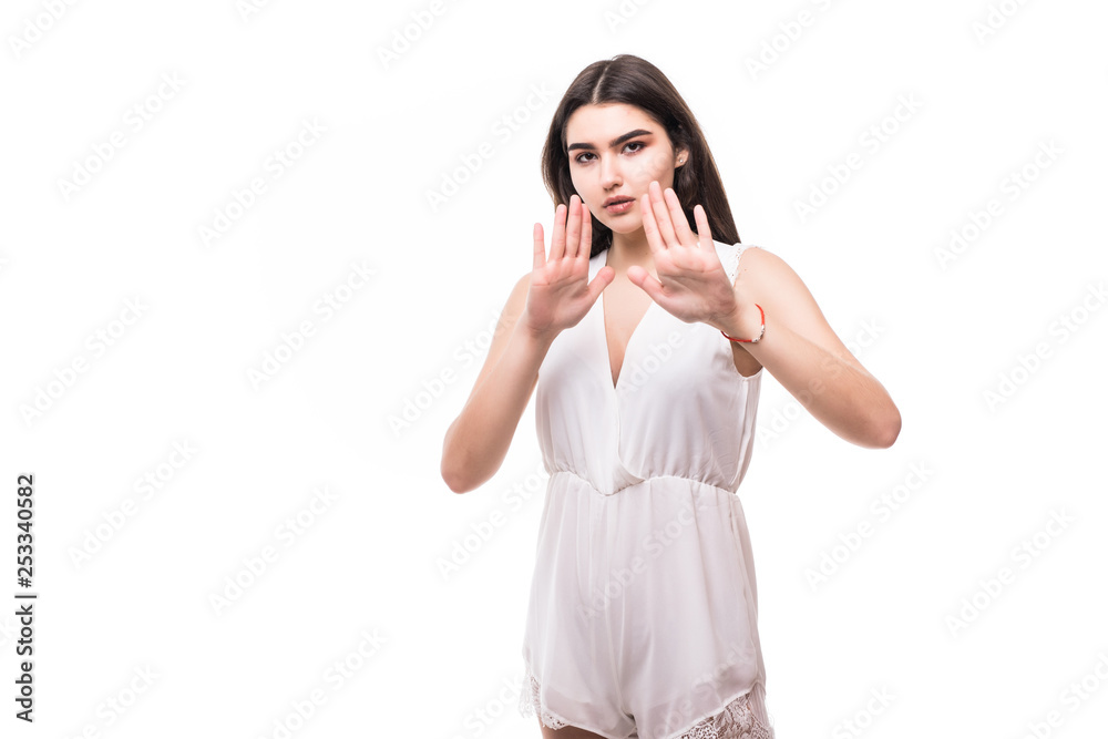 Portrait of a serious young woman standing with outstretched hand showing stop gesture isolated over white background Portrait of a serious young woman standing with outstretched hand showing stop gesture isolated over white background
