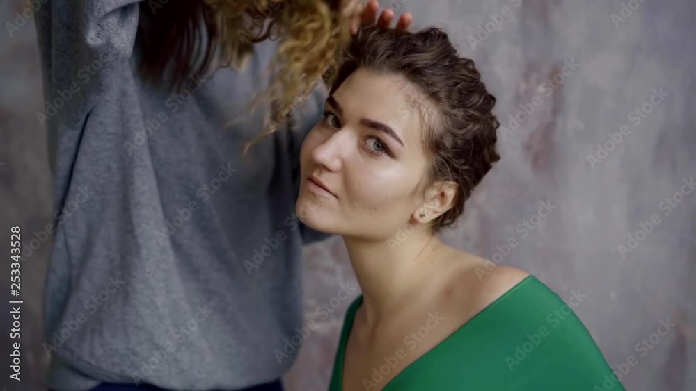 portrait of a young girl prepare for a photo session hairdresser makes hairstyle model