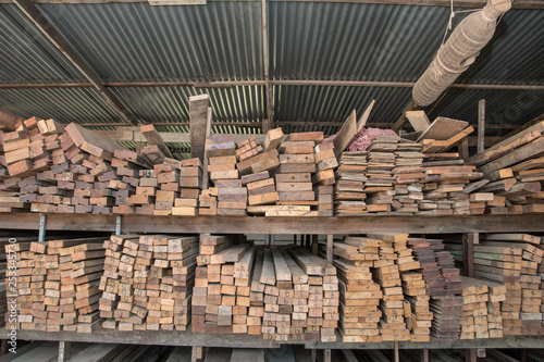 Piles of old wooden boards in the sawmill   Warehouse for sawing boards on a sawmill indoors. Wood timber stack of wooden blanks construction material. Industry  Vintage styles