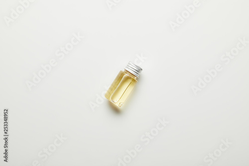 Top view of essential oil in bottle on white surface