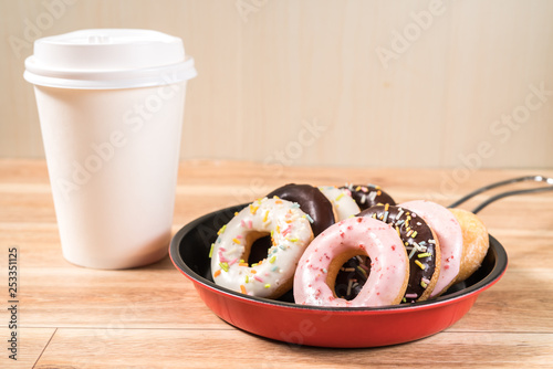 Donuts and drink and iron frying panon wood table background top view copy space pattern photo