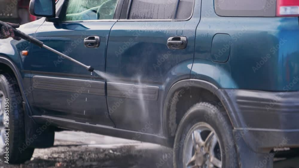 A worker washes the car thoroughly