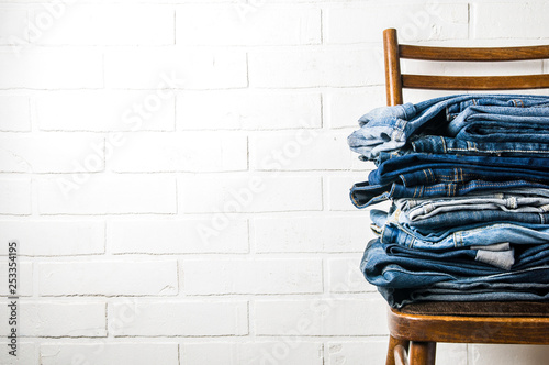 A stack of old jeans on a light background