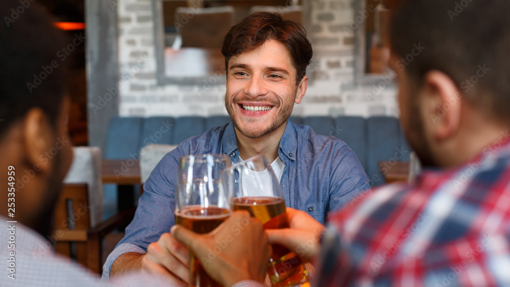 Friends drinking beer, celebrating meeting in bar