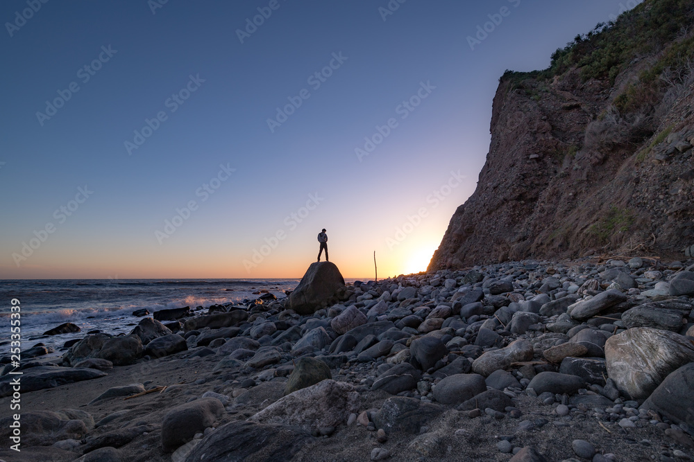 Man Posed on a Rock at Sunset