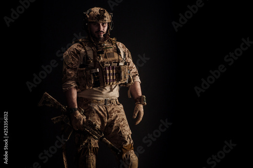 Special forces United States soldier or private military contractor holding rifle. Image on a black background. war, army and people concept