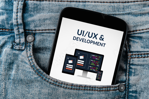 UI/UX design and development concept on smartphone screen in jeans pocket
