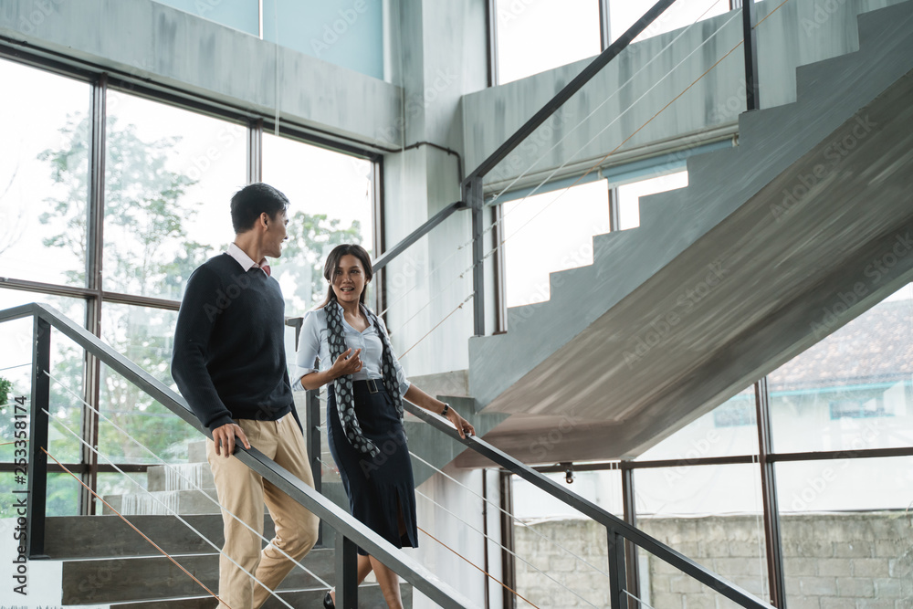 business people walking on stairs in the office and chatting