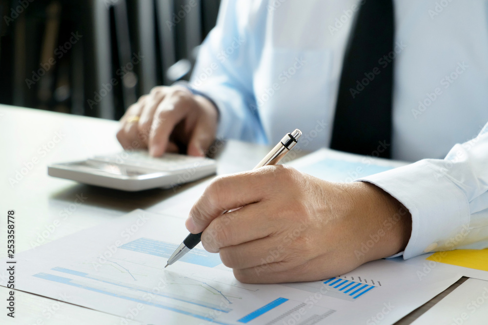 business man calculating about fee tax information in modern office. business man calculating about fee tax information in modern office.