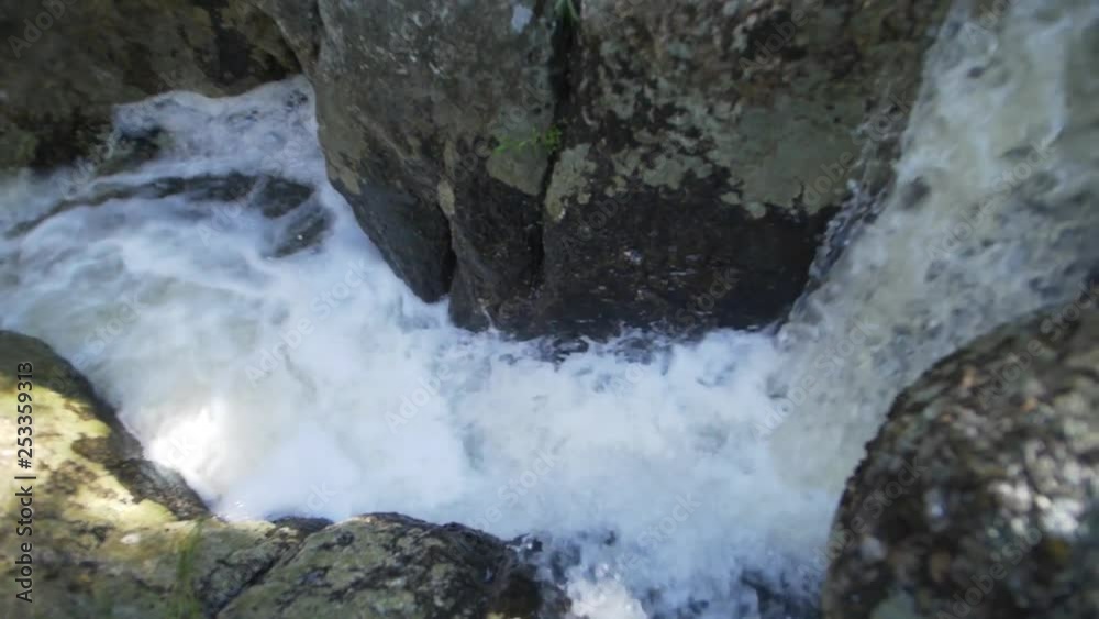 Small waterfall on rocks slow motion white water, from top angle Small waterfall on rocks slow motion white water, from top angle