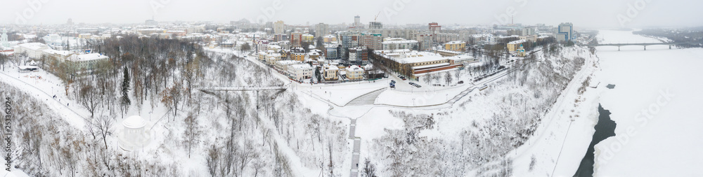 Obraz premium the city of Kirov and the high bank of the river Vyatka and the Alexander Grin Embankment and the rotunda on a cloudy winter day.