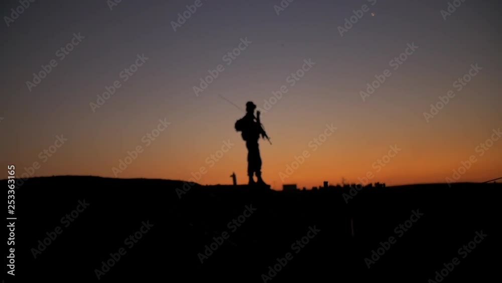 Soldier guarding military camp on mountain at sunset. Soldier guarding military camp on mountain at sunset.