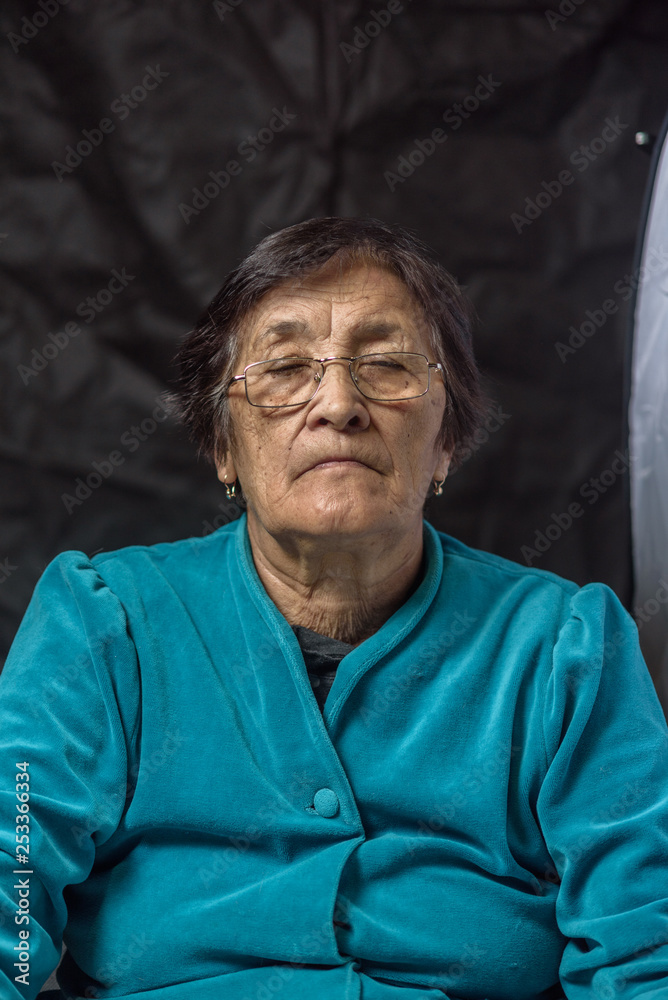 portrait of an elderly thoughtful woman on a dark background portrait of an elderly thoughtful woman on a dark background