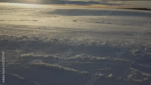 Snow drifting across a prairie field due to high winds. photo