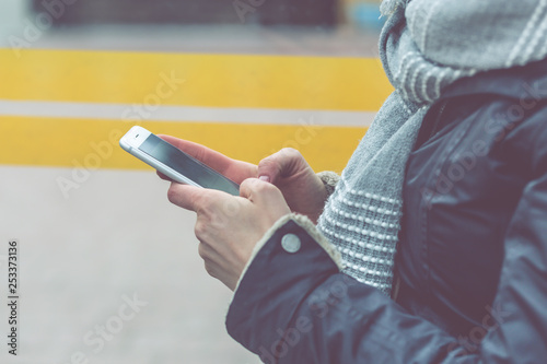Young woman uses a smartphone. Daily life of modern people. Shallow depth of field with instagram fliter and noise. photo