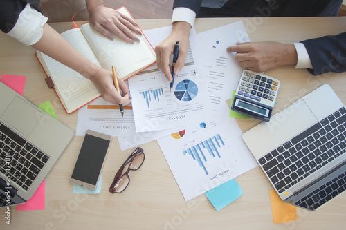 Businessmen are analyzing graphs and finding ways to increase sales in the next year., Top up business analysis and strategy concept. - image