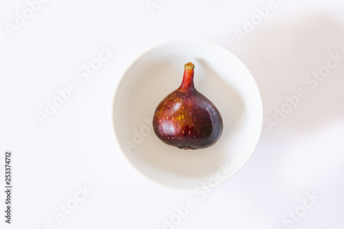 ripe figs on a white background in a white round bowl