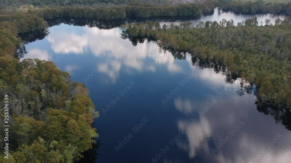 Reflections of the sky on still water as the leaves are beginning to change colors Reflections of the sky on still water as the leaves are beginning to change colors